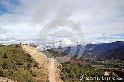 A yellow dirt road leads to the top of the mountain Stock Photo