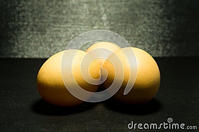 Yellow eggs on black pattern background Stock Photo