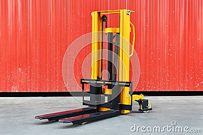 Yellow electric forklift pallet stacker crane in the warehouse front Stock Photo