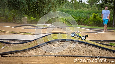 Yellow electric RC buggy racing on an offroad track Stock Photo