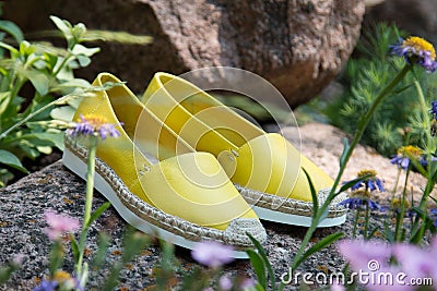 Yellow espadrilles on stones Stock Photo