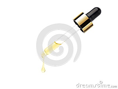 Yellow essential serum oil dripping from gold dropper Stock Photo