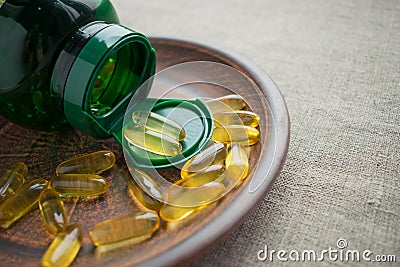 Yellow evening primrose seed oil gelatine capsules and green bot Stock Photo