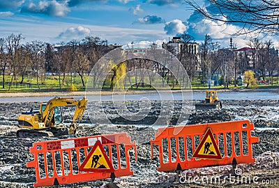 Yellow excavator doing lake cleaning and maintenance services Stock Photo