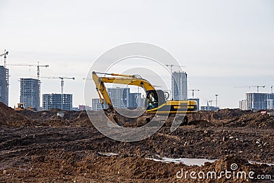 Yellow excavator during groundwork on construction site. Hydraulic backhoe on earthworks. Heavy equipment for demolition, Stock Photo