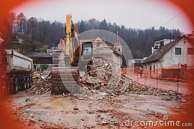 Yellow excavator on house Stock Photo