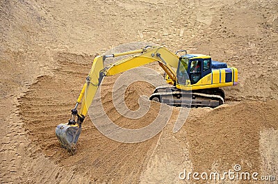 Yellow excavator levels its bucket of sand, earth, clay. Construction of a sand embankment Stock Photo