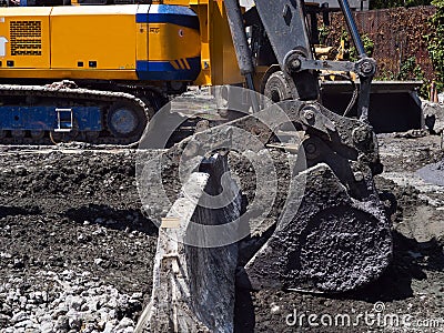 Yellow excavator moving heavy load of cement Stock Photo