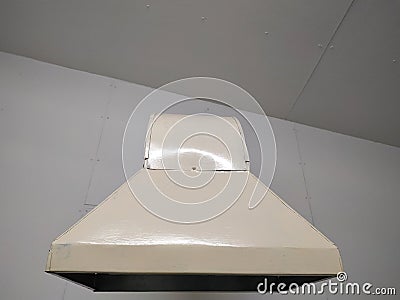 Yellow exhaust hood under the ceiling in the building. Stock Photo