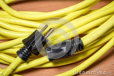 Yellow extension cord with black plugs Stock Photo