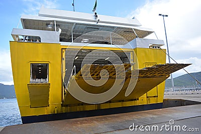 Passenger boat at the port. Yellow ferry opening for disembarking. Good weather in the sea Stock Photo