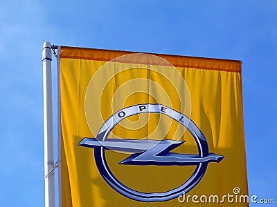 Yellow flag detail with blue sky background and OPEL car brand logo Editorial Stock Photo