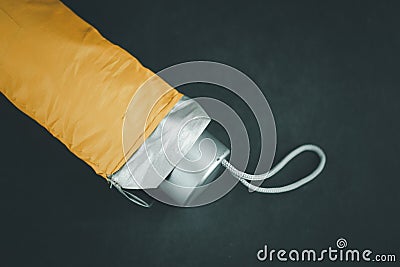 A yellow folding umbrella on black background Stock Photo