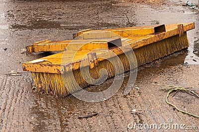 Yellow Forklift road sweeper brush attachment part in rainy yard Editorial Stock Photo