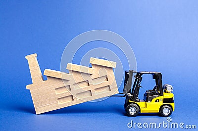 The yellow forklift transports the factory to another location. Relocation of harmful industrial production outside the city, Stock Photo