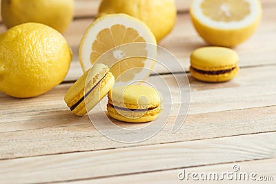 Yellow french macarons with lemons on the wooden board Stock Photo