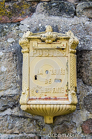 Yellow French Mailbox in Stone Wall Stock Photo