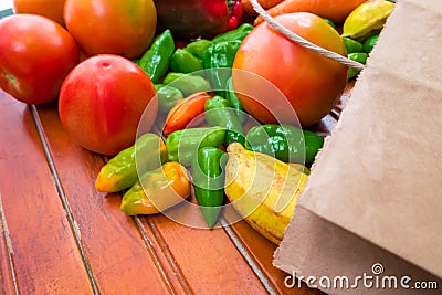 Yellow fruits and red, yellow and green vegetables on a wooden base. Healthy food. Multicoloured raw food Stock Photo