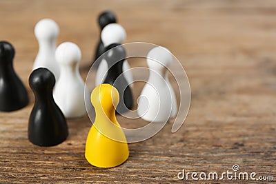 Yellow game piece among black and white ones on background, closeup. Career promotion concept Stock Photo