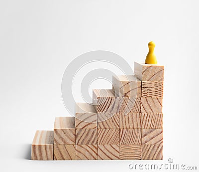 Yellow game piece on top of stairs against background. Career promotion concept Stock Photo