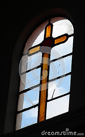 Yellow glass crux in a church Stock Photo