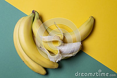 Yellow and green bananas on a colored background, ripe and unripe fruit concept Stock Photo