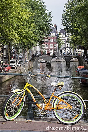 Yellow and green bike with buildings and old bridge Stock Photo