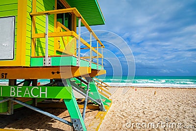 Yellow and green lifeguard tower in South Beach under a cloudy sky Stock Photo