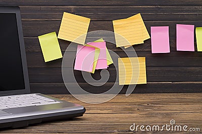 Yellow, green, pink reminder notes on a wooden board, empty space for text Stock Photo