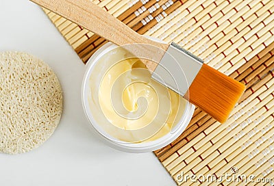 Yellow hair mask banana face cream, shea butter facial mask, body butter in the small white jar. Natural skin and hair concept. Stock Photo