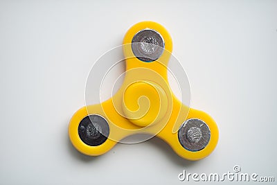 Yellow Hand Spiner. Stress relieving toy on white background. Close-up. Top view. Stock photo Stock Photo