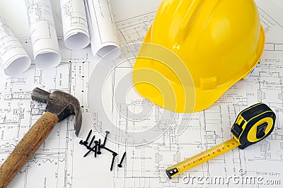 Yellow hard hat and heap of project drawings Stock Photo