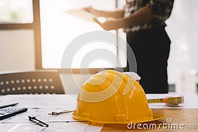 Yellow hard hat on workbench start plan contracting new project in construction office center and contractor concept Stock Photo