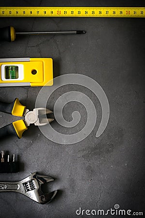 Yellow hardware tools on black concrete background with some space for text Stock Photo