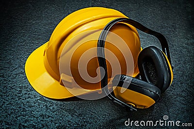 Yellow helmet and earphones on blackbackground Stock Photo