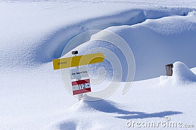 Yellow hiking sign in the snow of austria Stock Photo