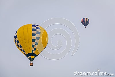 Yellow hot air balloon floats through the sky at dusk at Warren County Farmer`s Fair, Harmony, New Jersey, on 8/1/17 Editorial Stock Photo