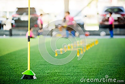 Yellow hurdles and ladder drills on green artificial turf with blurry coach and kid soccer Stock Photo