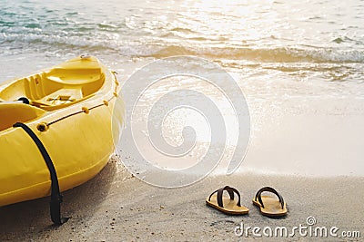 Yellow kayak and flip flop on the beach in sunset, summer time vacation holidays concepts, vintage tone soft focus Stock Photo