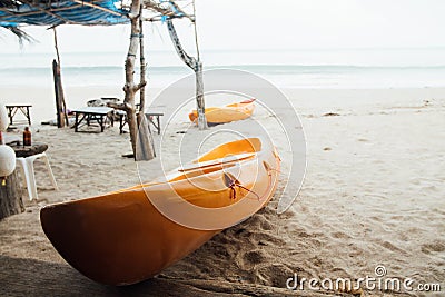 Yellow kayak on sandy beach sea. Two kayaks in sand on background sea. Stock Photo