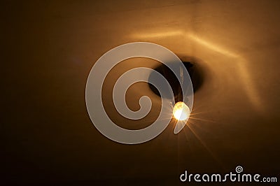 Yellow lamp in very dark room Stock Photo