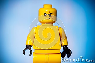 yellow lego figure with an evil face on a blue background Editorial Stock Photo