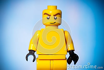 yellow lego figure with a sarcastic face on a blue background Editorial Stock Photo