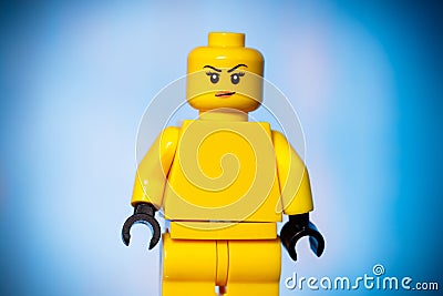 yellow lego figure with a sarcastic face on a blue background Editorial Stock Photo