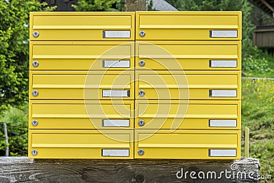 Yellow letterbox made of tin without name in a rural area, Austria Stock Photo