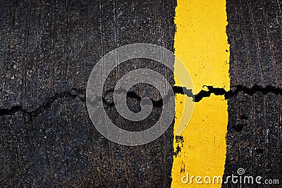 Yellow line on cracked asphalt road Stock Photo