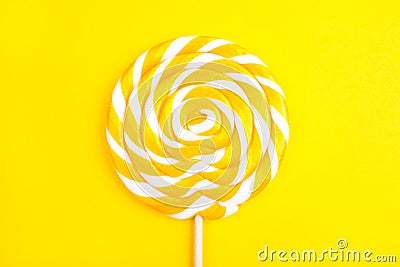 Yellow lollipop in the shape of a circle on a yellow background. Stock Photo