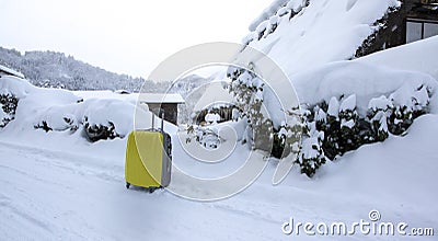 Yellow luggage on the road with snow as background Stock Photo