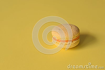 A yellow macaron on a minimalistic yellow background Stock Photo