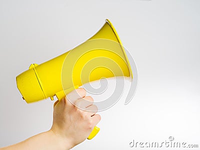 Yellow megaphone in a man`s hand on a white background. There is free space to insert. Loudspeaker, fake news, false news, Stock Photo